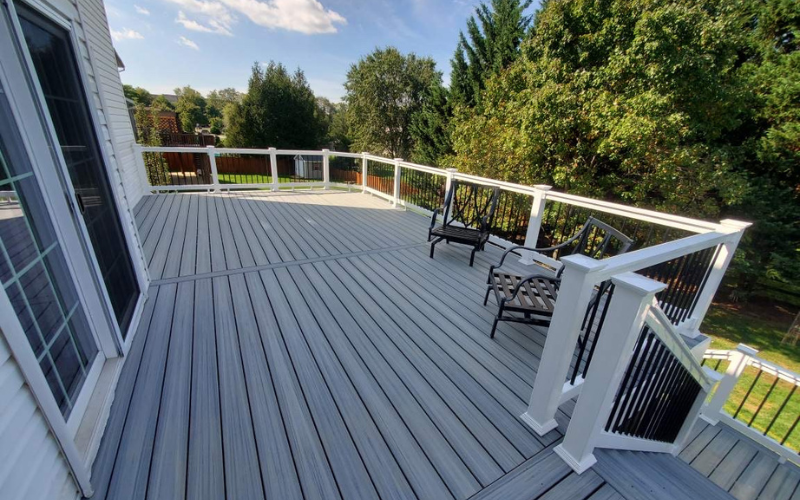 Expansive gray composite deck with white railing and outdoor seating, showcasing Bupp Contracting LLC’s quality deck installation.